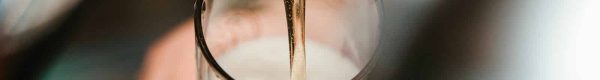 person filling clear glass with liquid