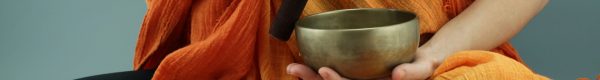 person in orange scarf holding silver round bowl